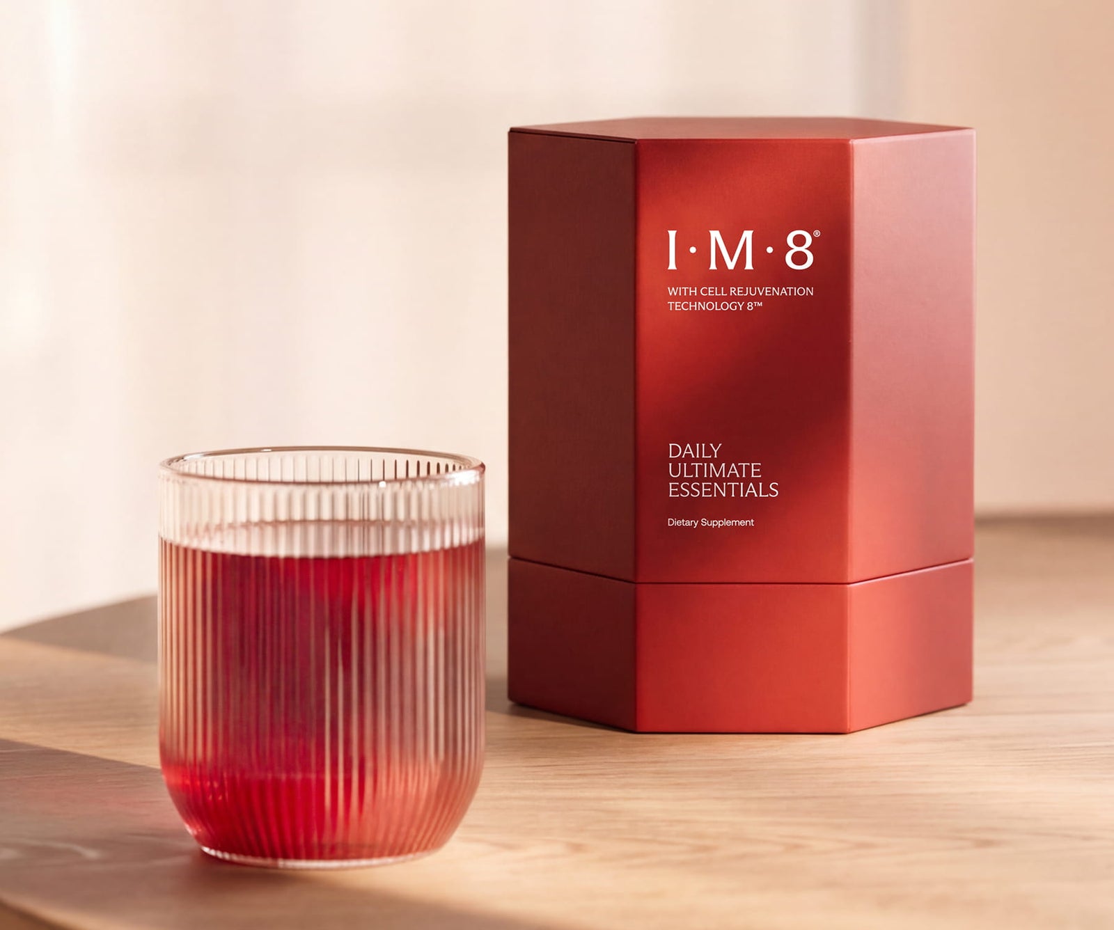The Beckham Stack Essentials Pro canister beside a glass of açaí berry drink